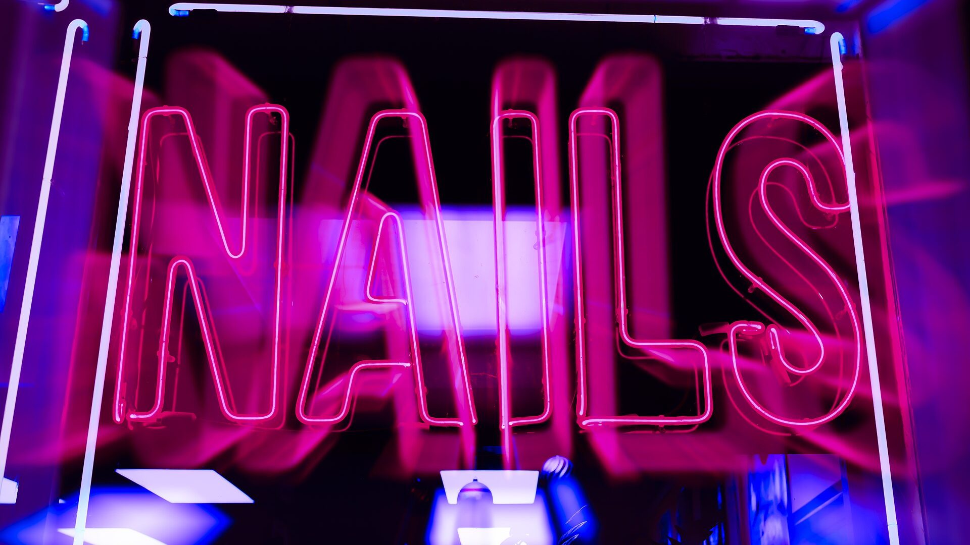 Pink neon script lettering typical of custom storefront signage