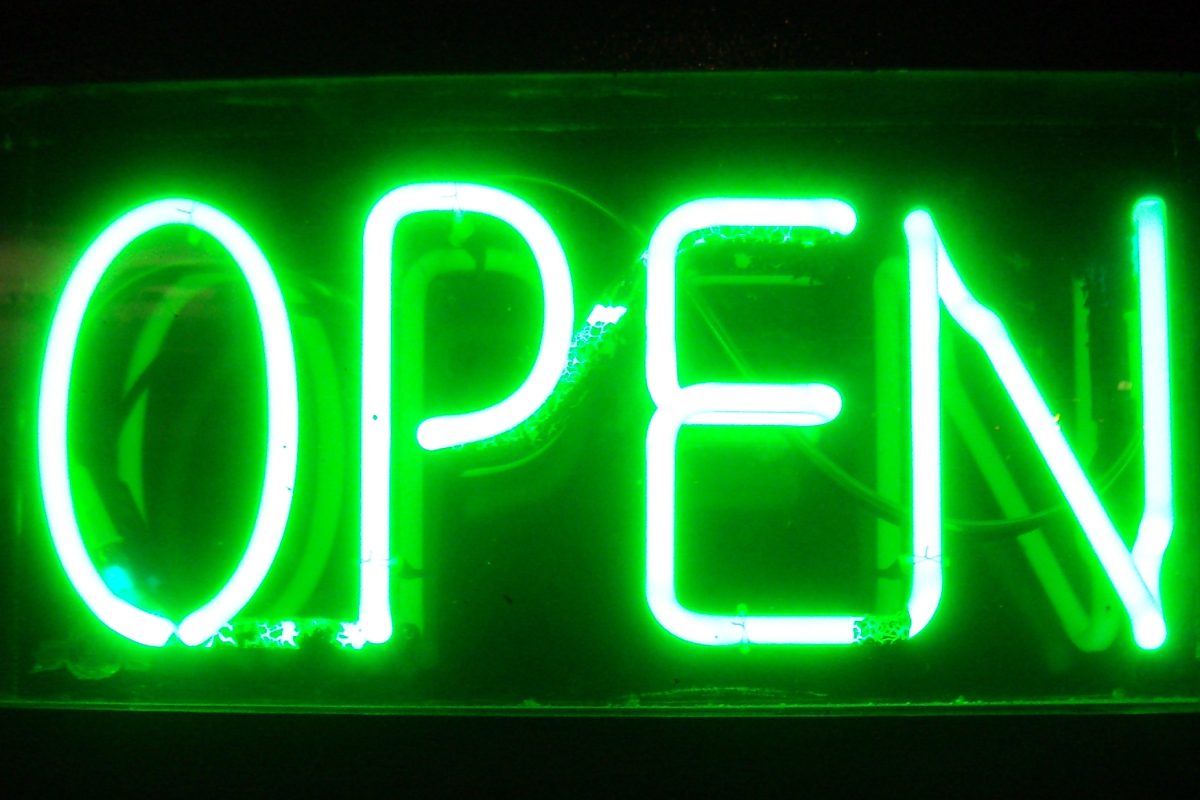 Close-up of a bright green neon block-letter OPEN sign