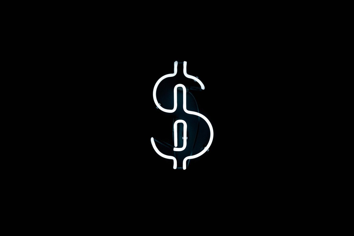 A single freestanding white neon sculptural symbol glowing against a black background