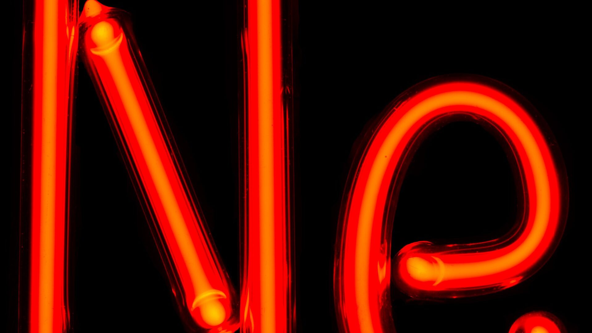 Close-up detail of hand-bent red-orange neon glass tubing