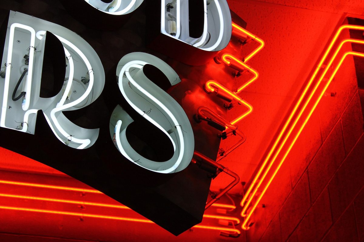 Close-up of dimensional channel letters with red and gold halo-lit neon backlighting