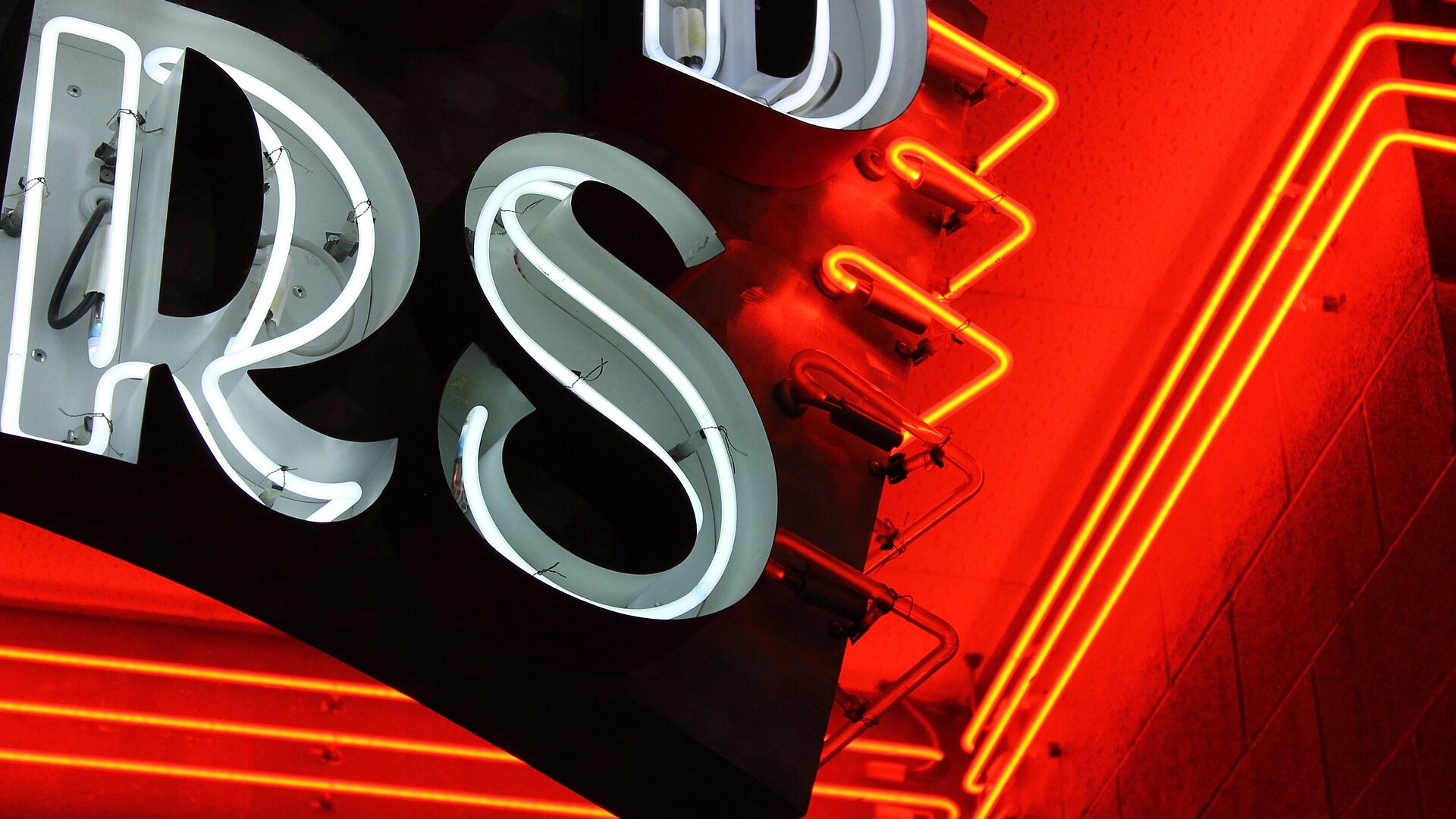 Close-up of dimensional channel letters with red and gold halo-lit neon backlighting