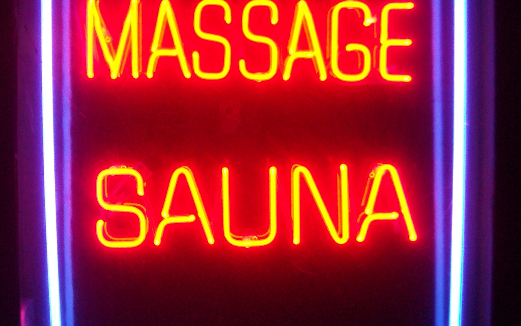 A multi-line neon sign combining red, yellow, and blue tube colors in one fixture